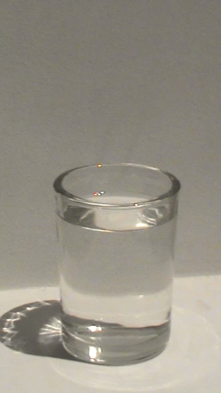 Pouring Skin Therapy powder into a glass of water